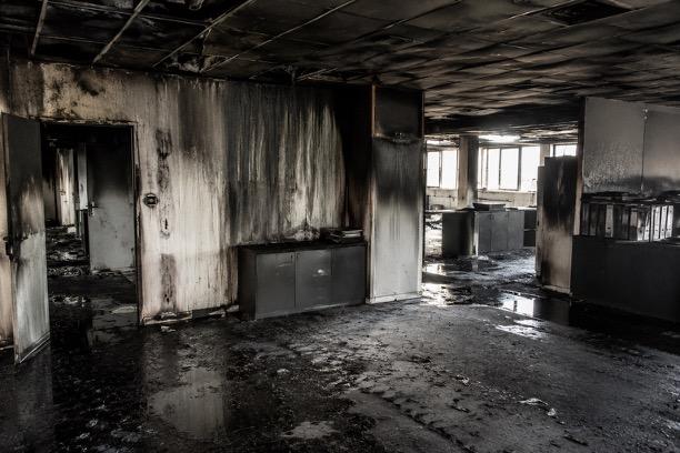Un mur de cuisine est couvert de suie noire après un incendie, avec des traces de nettoyage partiel visibles. Cette image illustre l'urgence d'une intervention pour le nettoyage après sinistre afin de restaurer l'état des lieux et minimiser les dégâts causés par le feu.