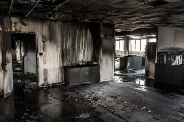 Un mur de cuisine est couvert de suie noire après un incendie, avec des traces de nettoyage partiel visibles. Cette image illustre l'urgence d'une intervention pour le nettoyage après sinistre afin de restaurer l'état des lieux et minimiser les dégâts causés par le feu.