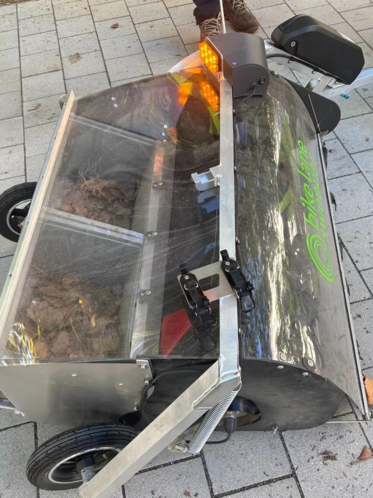 Remorque à vélo professionnelle utilisée pour la collecte de déchets et l’entretien des espaces urbains.